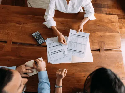 Person reviewing tax documents with calculator